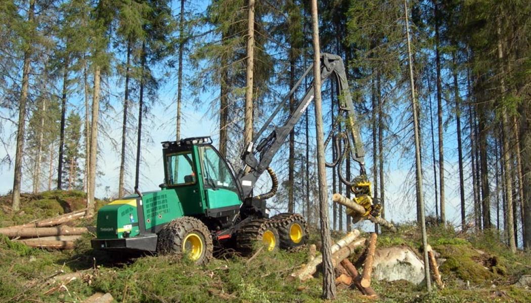 En hjulburen skördare från Timberjack staplar avverkat virke i Finland. Foto: Wikipedia Commons Lic: kredit: Heikki Valve

